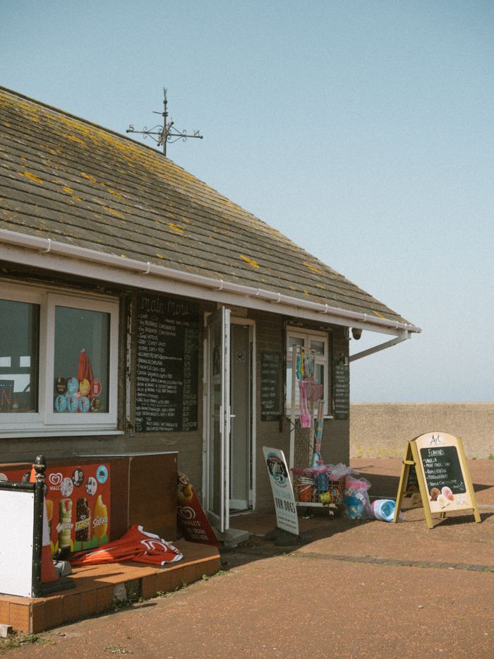 A quaint seaside shop with colorful signs and a vintage aesthetic, perfect for summer exploration.